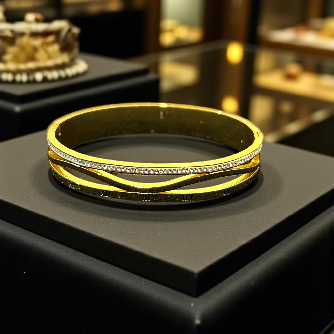 Gold bracelet on a black stand with blurred jewelry store background
