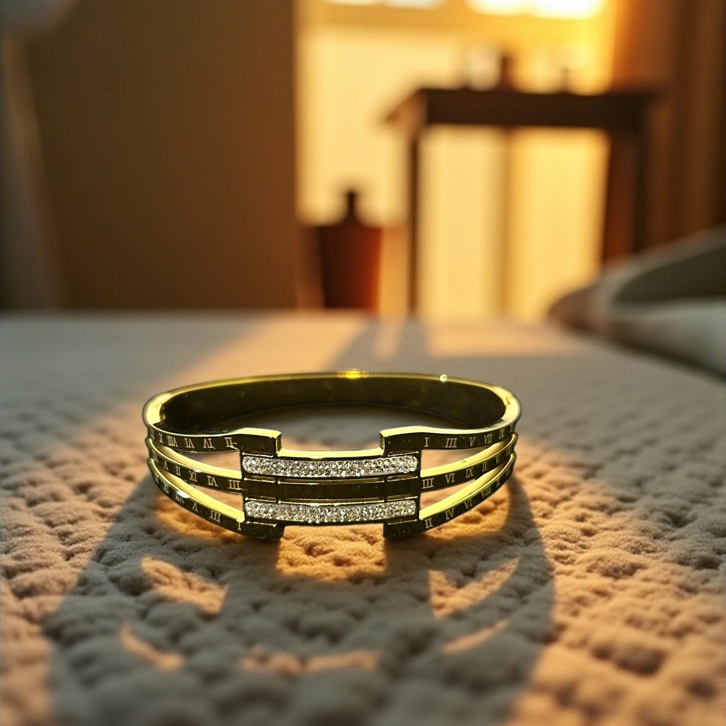 Gold bracelet with embedded stones on a textured surface
