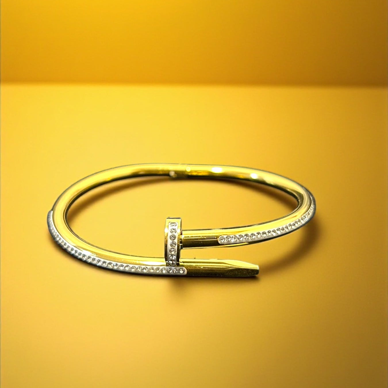 Gold bracelet with a unique design on a yellow background