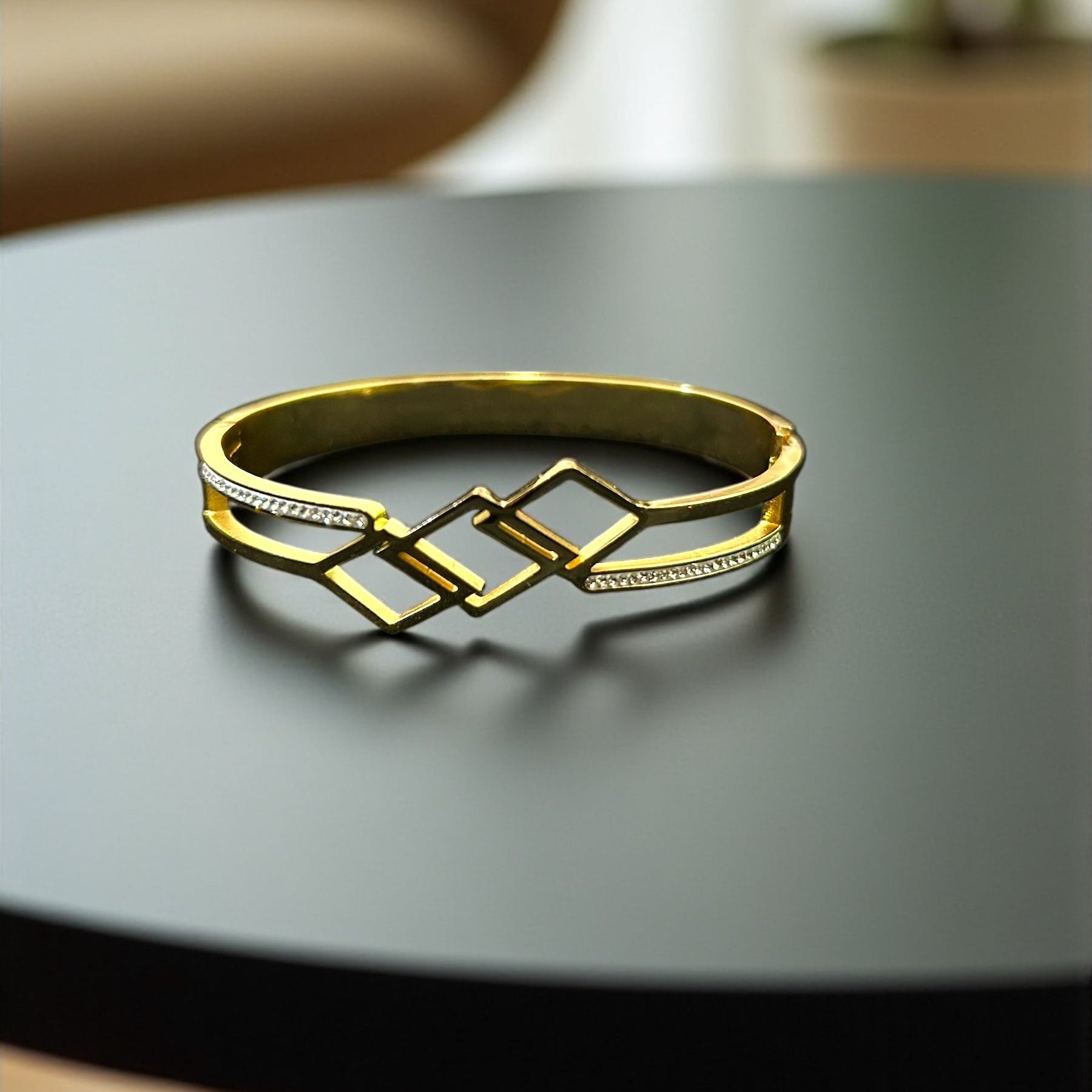 Gold bracelet on a dark surface with a blurred background