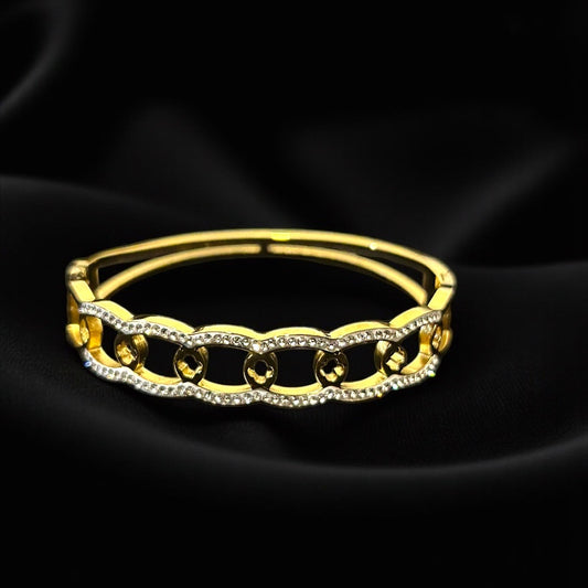 Gold bracelet on a black satin background