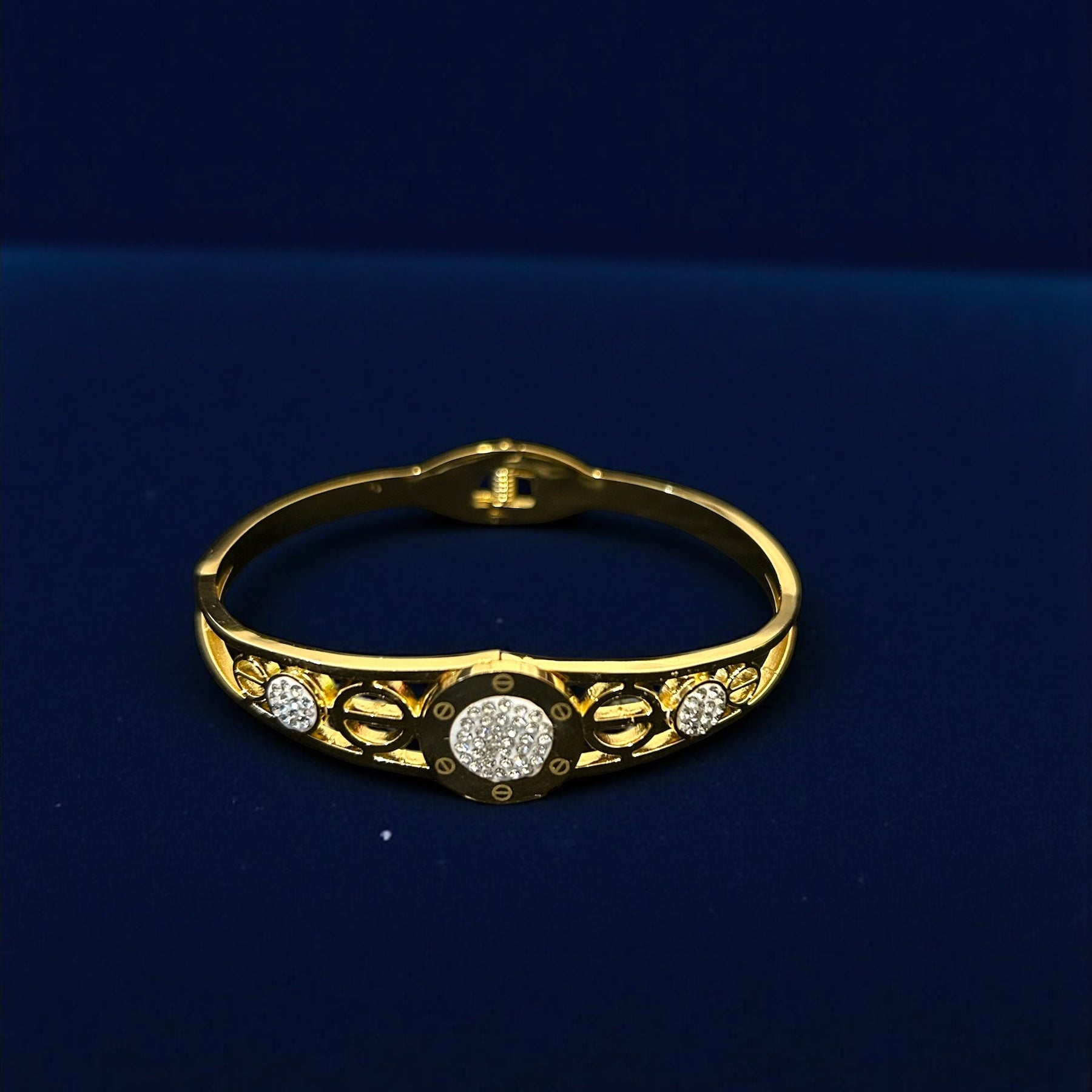 anti tarnish Gold colour bracelet with diamond accents on a dark blue background
